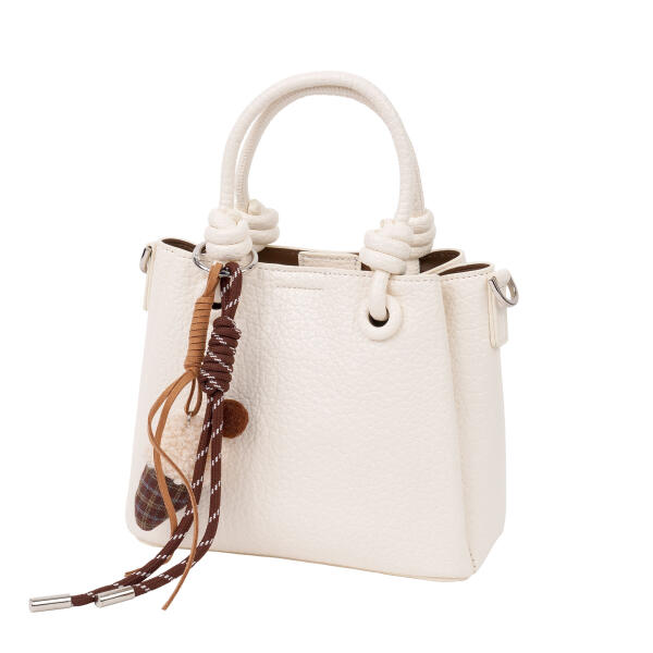 A stylish handbag with a decorative charm. image 4