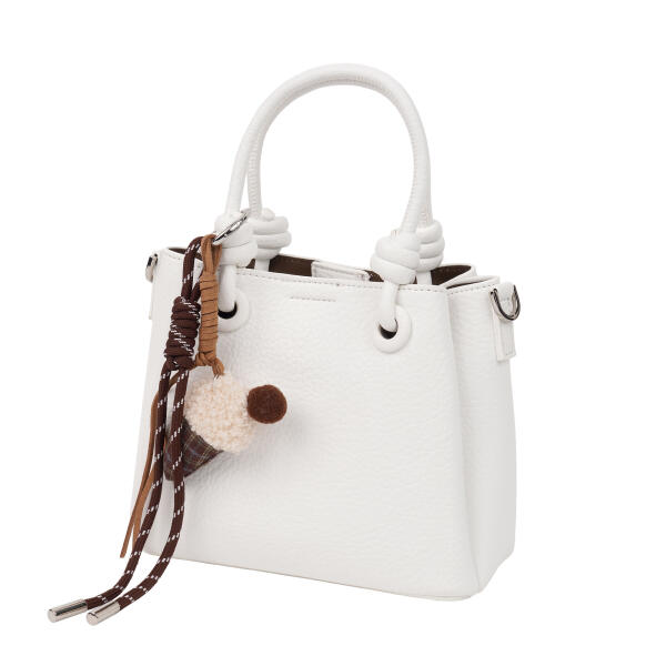 A stylish handbag with a decorative charm. image 2